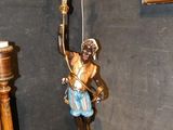 une statue d'ange posée sur une table, à côté d'une lampe