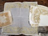 plusieurs morceaux de tissu ornés de motifs dorés, posés sur une table en bois