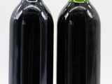 two bottles of wine sitting next to each other on a white surface