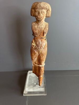 statue d'une femme coiffée d'un chapeau, posée sur un socle transparent