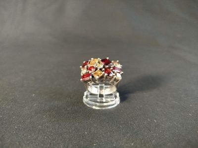 a red and gold ring sitting on top of a black surface