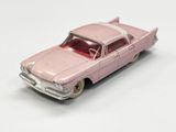 petite voiture rose posée sur une surface blanche, avec un fond blanc