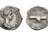 a close up of a coin with a hand on it