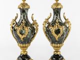 pair of black and gold vases with a dragon on the top