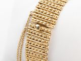 a close up of a gold bracelet on a white napkin