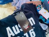 a shopping cart full of clothes and a t - shirt with a tag on it