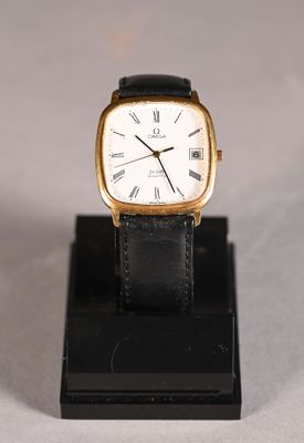 a close up of a watch on a stand on a white surface