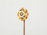 une fleur en or sur une tige, avec un diamant au centre