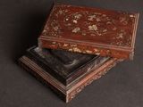 two wooden boxes sitting on top of each other on a black surface