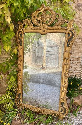 un grand miroir posé par terre à côté d'un mur de briques