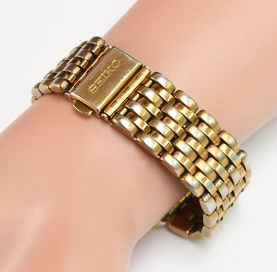 a close up of a person ' s hand wearing a gold bracelet