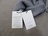 a tag on a piece of clothing that is on a couch
