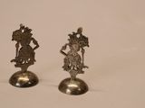 pair of silver figurines of a woman and a man on a pedestal
