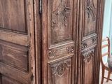 une armoire en bois, avec une chaise et une table devant