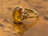 an image of a yellow ring sitting on top of a wooden table