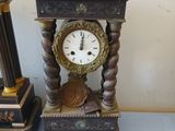 a clock that is sitting on a table next to a candle holder