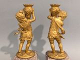pair of antique bronze figurines of a boy and a girl on marble bases
