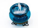 un bol en verre bleu sur lequel est représenté un homme