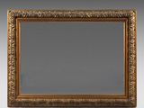 un miroir à cadre doré orné d'un motif décoratif sur fond gris