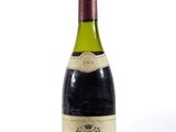 une vieille bouteille de vin posée sur une surface blanche