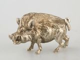 a silver figurine of a boar on a table