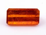 un gros plan d'une pierre de couleur orange sur une surface blanche