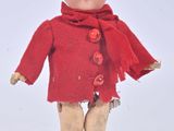 a small doll that is wearing a red coat and boots