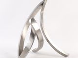 a close up of a metal sculpture on a white surface