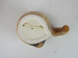 a small tea pot with a handle on a white table