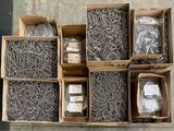several boxes of assorted screws and nails on a concrete surface