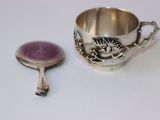 une tasse en argent et une cuillère posées sur une table