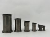 un ensemble de quatre vases en métal posés sur une surface blanche