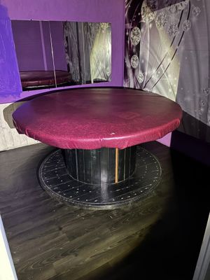une table ronde au plateau rouge dans une pièce violette