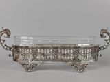 a large silverplated bowl with ornate design and handles