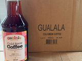 a bottle of coffee sitting next to a box on the floor