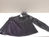 une chemise à rayures violettes et noires posée sur une table blanche, avec une cravate noire