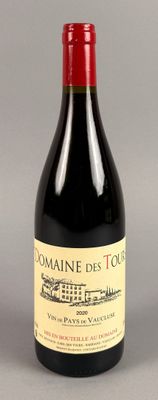 une bouteille de vin rouge posée sur une table à côté d'un verre de vin