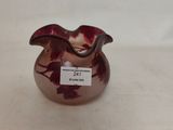 a glass vase with a red flower inside of it