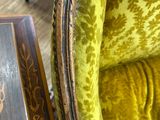 a chair that has a green velvet upholstered on it
