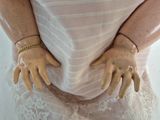 a close up of a mannequin wearing a dress and gold bracelet