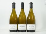 trois bouteilles de vin posées sur une table l'une à côté de l'autre