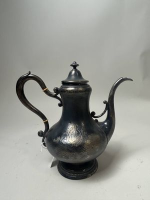 an antique silver tea pot with a black handle on a white surface