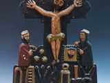 une statue de Jésus sur la croix, entourée de personnes
