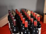 many bottles of wine sitting on a red table cloth