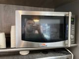 someone taking a picture of themselves in a microwave in a kitchen