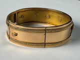 a close up of a gold bracelet on a table
