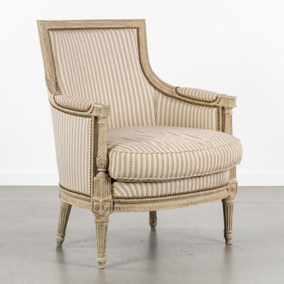 une chaise rayée de beige et de blanc posée sur un parquet en bois massif