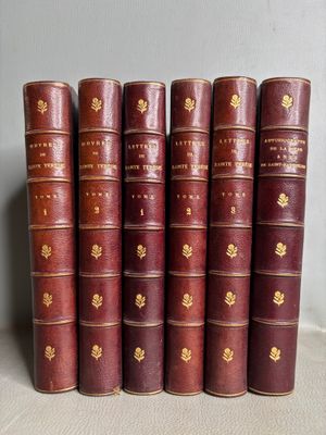 six vieux livres sont alignés sur une table
