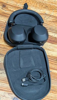 an image of a pair of headphones in a case on a wooden floor