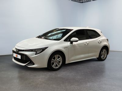 une Toyota Corolla blanche garée dans une grande pièce